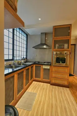 a kitchen with wooden cabinets and stainless steel appliances at 1Min Pavilion Bukit Bintang KLCC Wisma Cosway in Kuala Lumpur