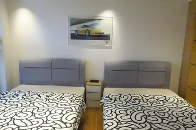 two beds in a room with a picture of a car on the wall at 1Min Pavilion Bukit Bintang KLCC Wisma Cosway in Kuala Lumpur