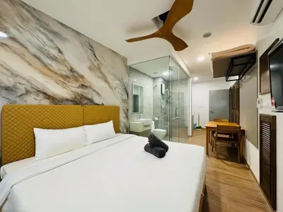 a bedroom with a bed with a black cat sitting on it at Riveria City By Dream stay in Kuala Lumpur