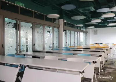 a row of tables and chairs in a room with windows at Riveria City By Dream stay in Kuala Lumpur