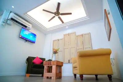 a living room with two chairs and a ceiling fan at Redstone Boutique Hotel Kuala Lumpur in Kuala Lumpur