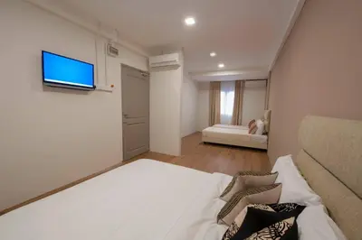 a bedroom with a bed and a tv on a wall at Redstone Boutique Hotel Kuala Lumpur in Kuala Lumpur