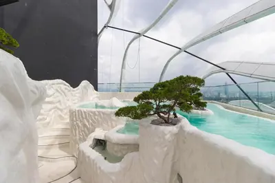 a bonsai tree in a building with a swimming pool at Gaming World Suite In Arte Mont Kiara in Kuala Lumpur