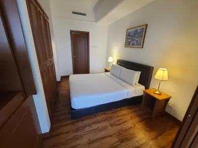 a bedroom with a white bed and a table and a lamp at KL BRB sarvice suite at time square in Kuala Lumpur