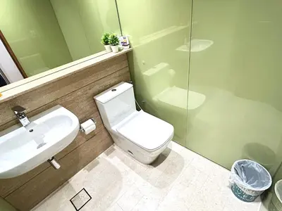 a bathroom with a white toilet and a sink at Sky Suites KLCC by NADIA in Kuala Lumpur
