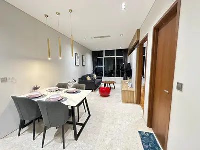a dining room and living room with a table and chairs at Sky Suites KLCC by NADIA in Kuala Lumpur