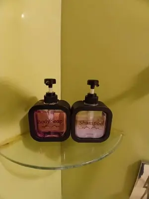 two bottles of soap sitting on a glass shelf at VORTEX SUITS KLCC by MMHB in Kuala Lumpur