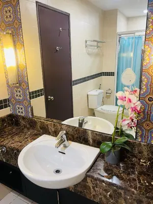 a bathroom with a sink and a mirror and a toilet at Seri Bukit Ceylon Suites Bukit Bintang in Kuala Lumpur