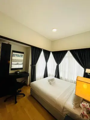 a bedroom with a bed and a desk and a television at Seri Bukit Ceylon Suites Bukit Bintang in Kuala Lumpur