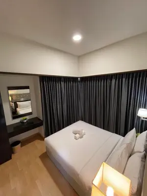 a bedroom with a white bed and a couch at Seri Bukit Ceylon Suites Bukit Bintang in Kuala Lumpur