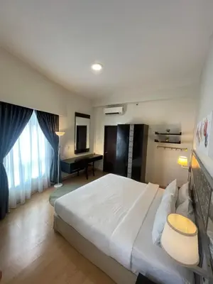 a bedroom with a large white bed and a desk at Seri Bukit Ceylon Suites Bukit Bintang in Kuala Lumpur