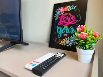 a desk with a computer keyboard and a vase of flowers at Agile Bukit Bintang by DeUrban in Kuala Lumpur