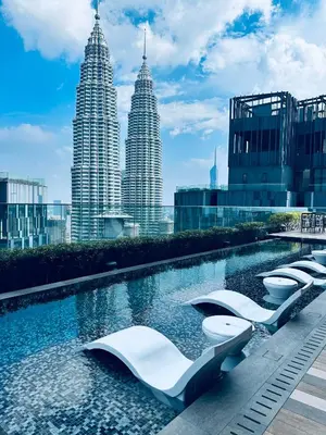 a pool with white toilets in front of the petronas towers at Star Residence KL in Kuala Lumpur