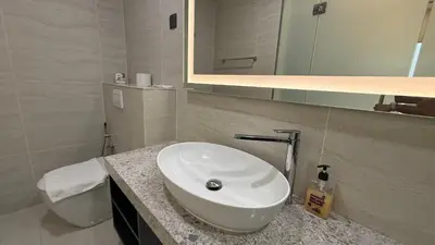 a white bathroom with a sink and a mirror at Star Residence KL in Kuala Lumpur