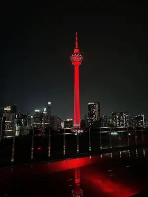a red lighted tower in a city at night at M101 Sky Suites at Dang Wangi KLCC in Kuala Lumpur
