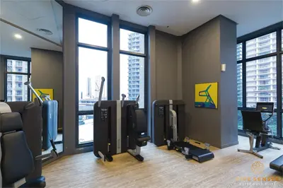 a gym with large windows and exercising equipment in a building at The Mews KLCC, Five Senses in Kuala Lumpur