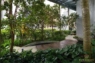 a garden with trees and a wooden walkway at The Mews KLCC, Five Senses in Kuala Lumpur