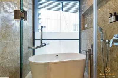 a bathroom with a tub and a glass shower at Dorsett Kuala Lumpur, Five Senses in Kuala Lumpur