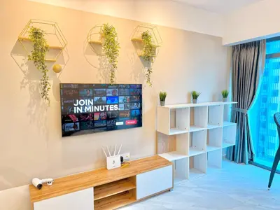 a living room with a tv on a wall at T Hotel Eaton by Klcc in Kuala Lumpur