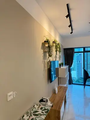 a living room with white walls and a wooden table at T Hotel Eaton by Klcc in Kuala Lumpur
