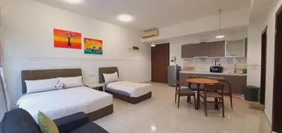 a hotel room with two beds and a kitchen at BEST KL City View at Regalia Residence in Kuala Lumpur