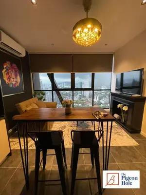 a dining room table with two chairs and a chandelier at KLCC Scarletz Executive Suite by ThePigeonHole in Kuala Lumpur