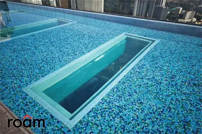 a swimming pool with blue water in a building at The Riv, Riveria City KL Sentral in Kuala Lumpur