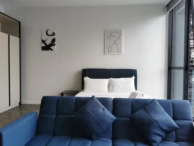 a bedroom with a blue couch in front of a bed at Scarletz Suites KLCC by De Harlequins Suite in Kuala Lumpur