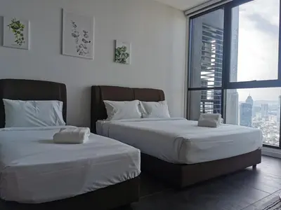 two beds in a room with a large window at Scarletz Suites KLCC by De Harlequins Suite in Kuala Lumpur