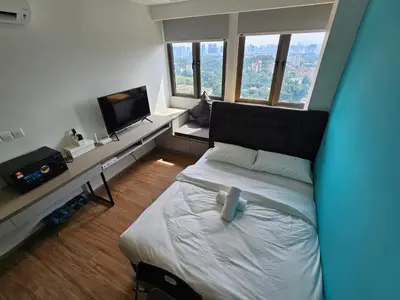 a small bedroom with a bed and a tv at Riveria City by Nomadnest in Kuala Lumpur