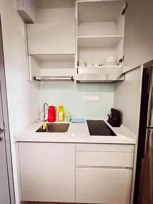 a small kitchen with white cabinets and a sink at Riveria City by Nomadnest in Kuala Lumpur