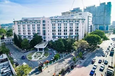 a large white building with cars parked in a parking lot at Cemara Premier Residence Ampang Near KLCC Kuala Lumpur in Kuala Lumpur