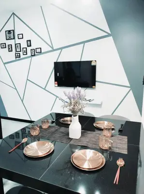 a black table with plates and a vase with flowers at Neu Suites Cozy Family House KLCC in Kuala Lumpur