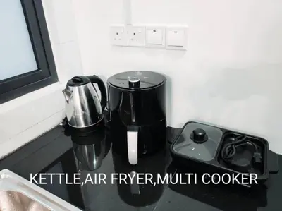 a kitchen counter with a coffee maker and a blender at Neu Suites Cozy Family House KLCC in Kuala Lumpur