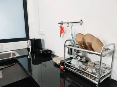 a kitchen with a metal rack with plates on it at Neu Suites Cozy Family House KLCC in Kuala Lumpur