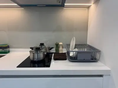 a kitchen counter with a stove with pots and pans at Alfa Bangsar By Nova Host in Kuala Lumpur