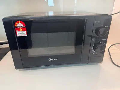 a black microwave on a counter with a tag on it at Alfa Bangsar By Nova Host in Kuala Lumpur