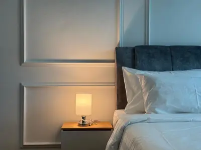 a lamp on a night stand next to a bed at Alfa Bangsar By Nova Host in Kuala Lumpur