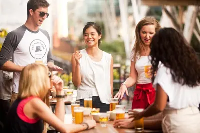 a group of people standing around a table with drinks at Lantern Hotel in Kuala Lumpur