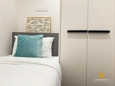 a bedroom with a bed with a blue pillow at 8 Kia Peng Suites KLCC By HeyStay Management in Kuala Lumpur