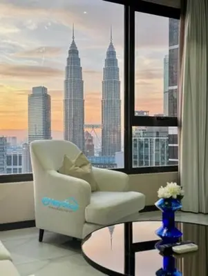 a living room with a chair and a glass table at 8 Kia Peng Suites KLCC By HeyStay Management in Kuala Lumpur