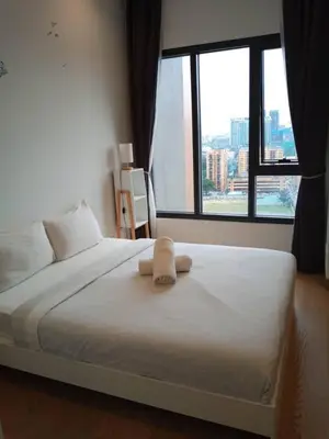 a bedroom with a white bed with a large window at Lotus Suite Scarletz KLCC in Kuala Lumpur