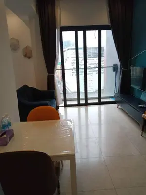 a living room with a table and chairs and a sliding glass door at Lotus Suite Scarletz KLCC in Kuala Lumpur