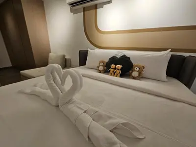 two stuffed animals sitting on a bed with towels at Agile Bukit Bintang by Fantastic Home in Kuala Lumpur