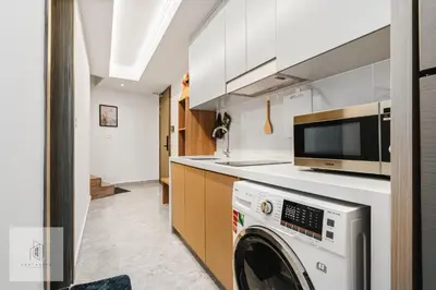a kitchen with a washing machine and a microwave at Agile Bukit Bintang by Fantastic Home in Kuala Lumpur