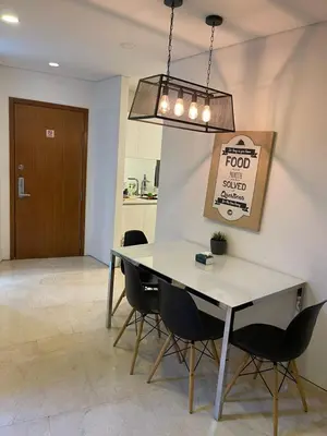 a dining room with a table and chairs and a sign at Vortex Suites KL33 in Kuala Lumpur