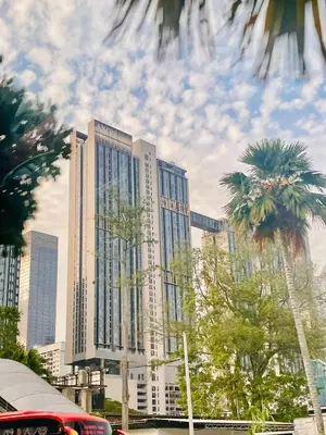 a tall building with palm trees in front of it at Axon Home Stay by Privet Apartment in Kuala Lumpur