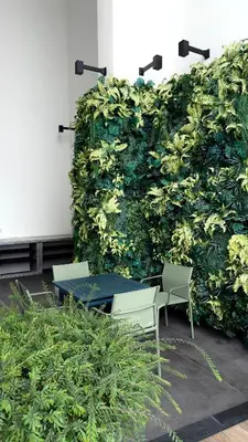 a green wall with two chairs and a table at The Home by Fidi at Continew Residence in Kuala Lumpur