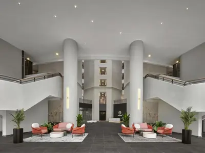 a lobby with orange chairs and a building at The Atrium at Jalan Ampang by OKBnB - 3Bedroom Apartment with FREE WiFi & Carpark in Kuala Lumpur