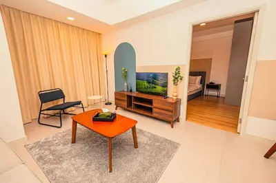 a living room with a television and a table at The Atrium at Jalan Ampang by OKBnB - Beautiful 2Bedroom nearby KLCC in Kuala Lumpur